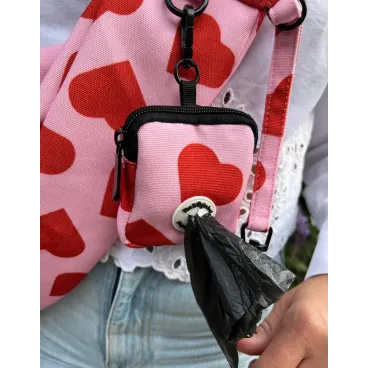 Détail du sac à crottes et du tissu cœur rouge du sac Amore pour petit chien