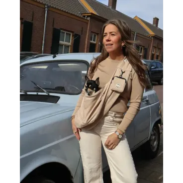 Une jeune femme portant son petit chien dans le sac à bandoulière léopard de the dog label